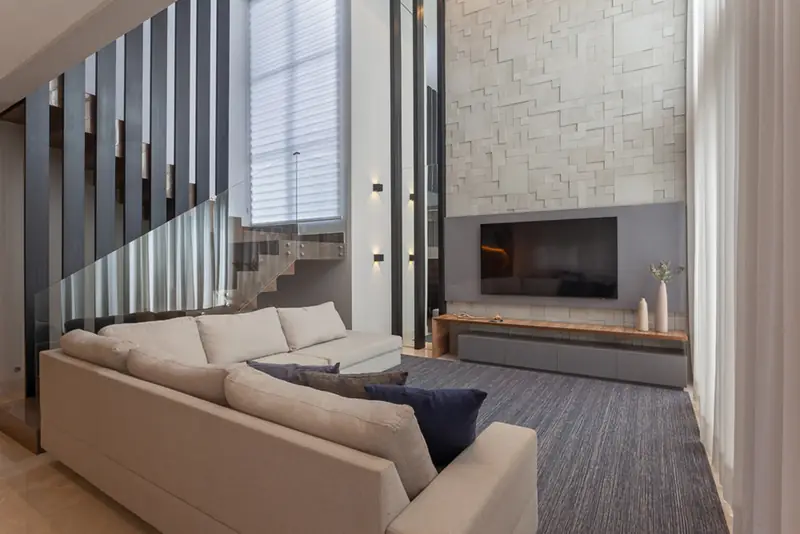 Sala de estar com escada e painel em pedra